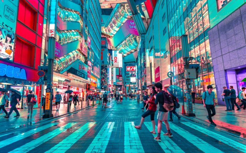 people walking on road near well-lit buildings