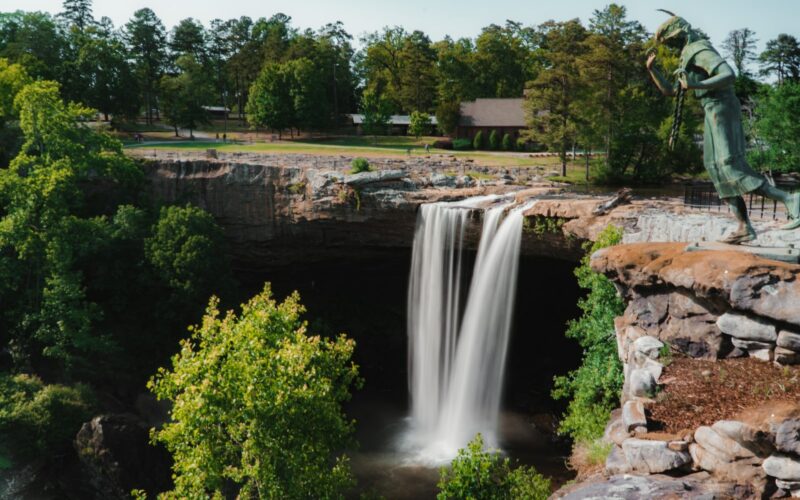 waterfalls near green trees during daytime