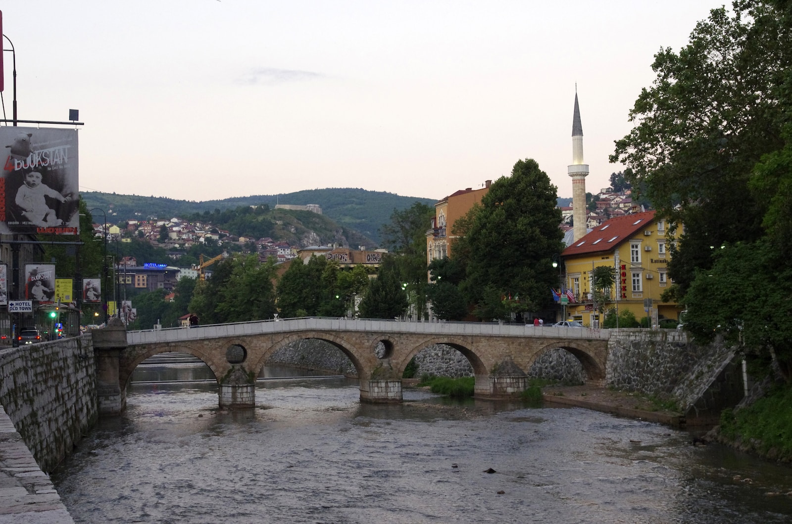 a bridge over a river with a church in the background