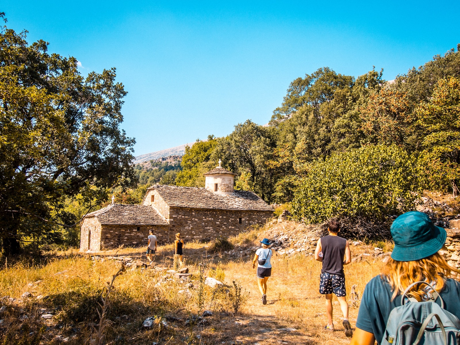 a group of people walking down a dirt road