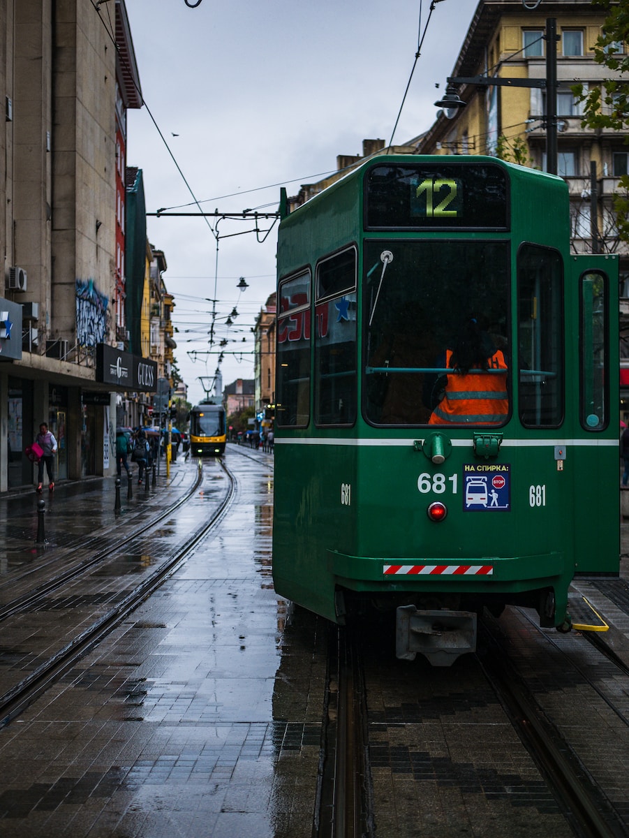 green tram on the street during daytime